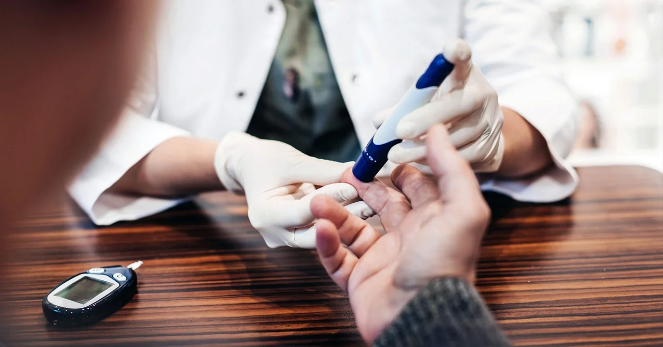 doctor pricking patient's finger