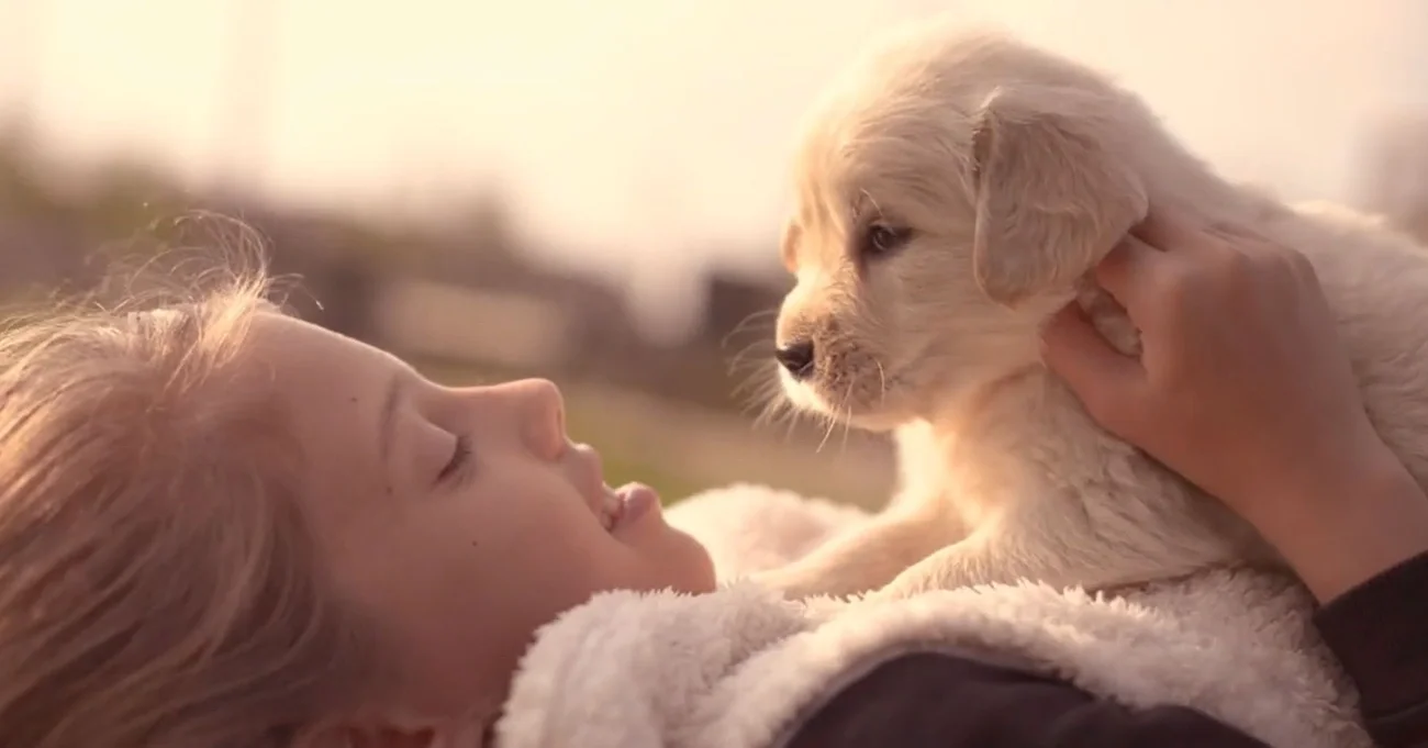 smiling person holding puppy